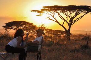Couple safari in Tanzania enjoying sunset view during Friends and Couples group safari experience