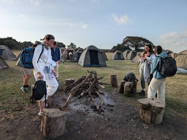 Group travel in Tanzania safari at Ngorongoro Conservation Area with tourists enjoying camping and campfire experience